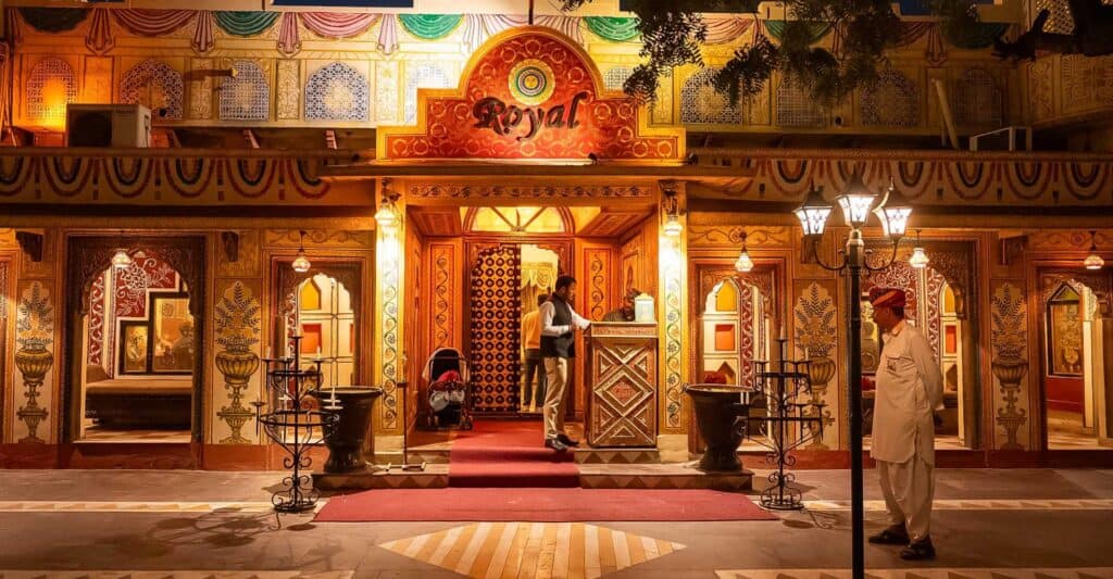A wide view of Chokhi Dhani, showing traditional Rajasthani huts and festive decorations under evening lights.