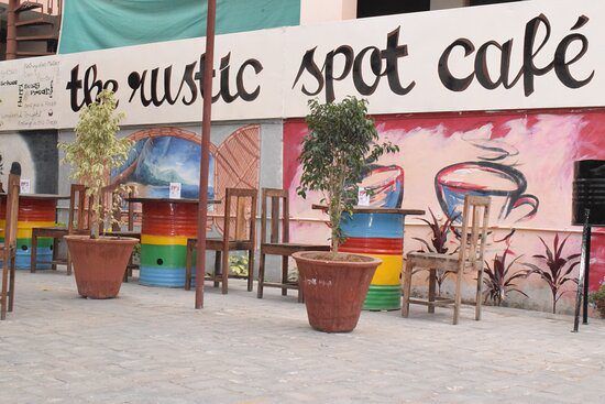 A small seating nook at The Rustic Spot Cafe, highlighted by warm, low lighting and wooden decor, creating an intimate, comfortable space for reading or dining.
